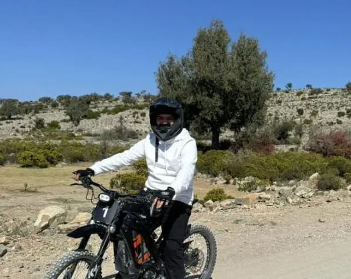 A person on a mountain bike in a rocky outdoor setting with sparse vegetation. 2