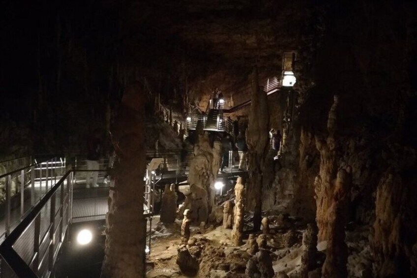 A cave with stalactites, a staircase, and a railing. 4