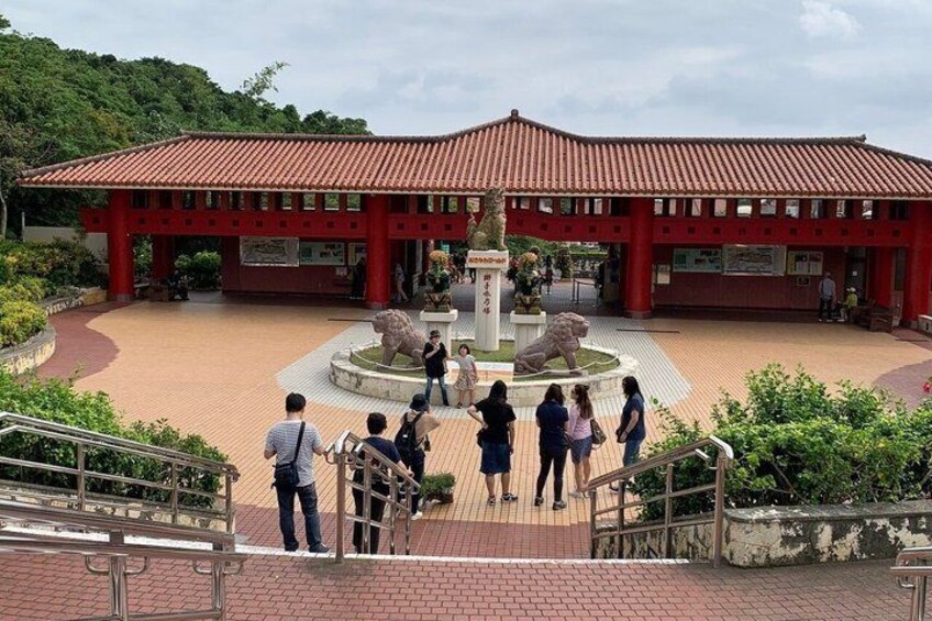 A red-roofed building with a central fountain, surrounded by a brick pathway and greenery. 2