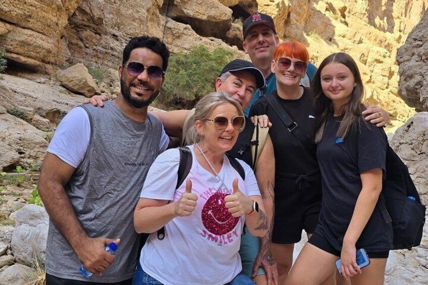A group of people posing in a rocky outdoor setting. 1