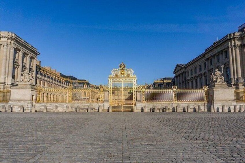 A grand palace with ornate golden gates and classical architecture. 1
