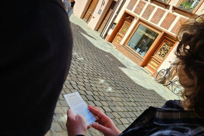 A cobblestone street with a building labeled 'cristalolosch' in the background. 5