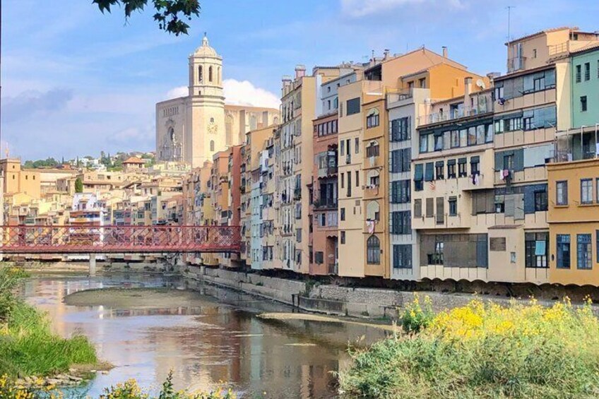 A river with buildings along its banks, a bridge, and a prominent church tower in the background. 4