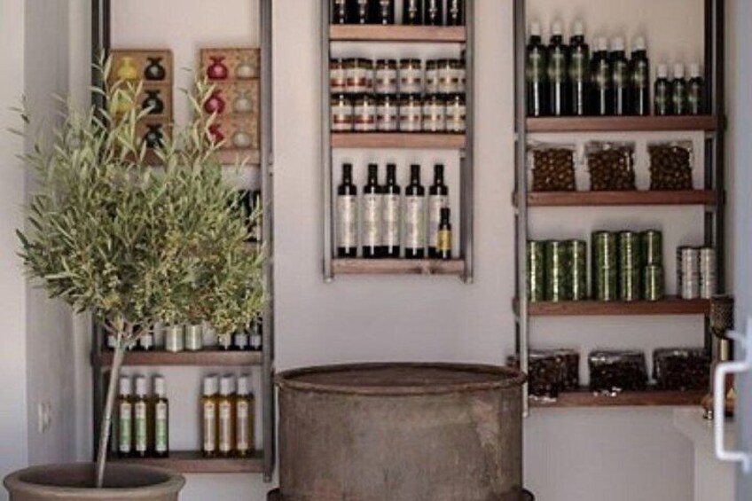 A room with shelves of bottles and jars, a large metal barrel, and a potted plant. 3