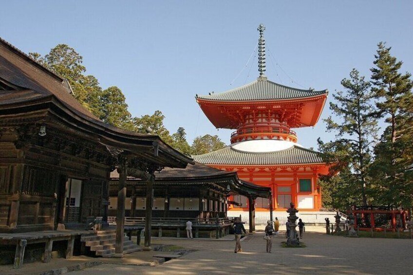 A traditional Japanese pagoda with a red and white color scheme, surrounded by a stone pathway and traditional architecture. 3