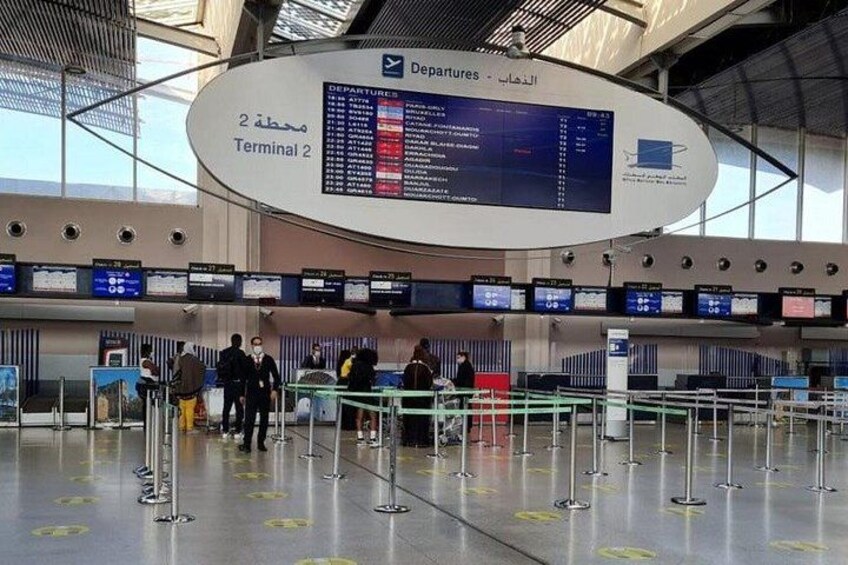 An airport departure board at Terminal 2 with flight information. 5