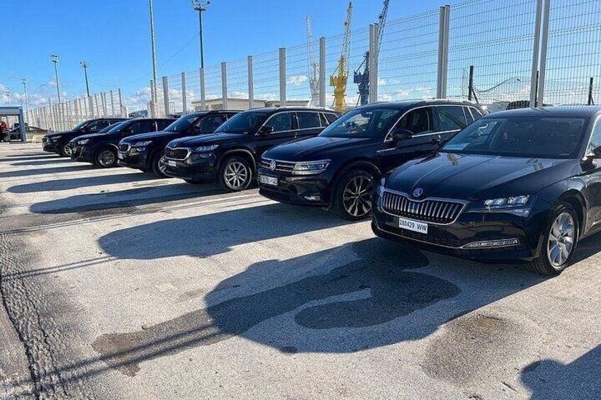 A parking lot with multiple cars, including a black sedan and a silver SUV. 4