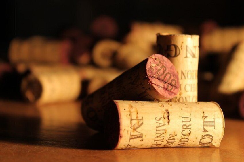A collection of wine corks on a wooden surface. 2