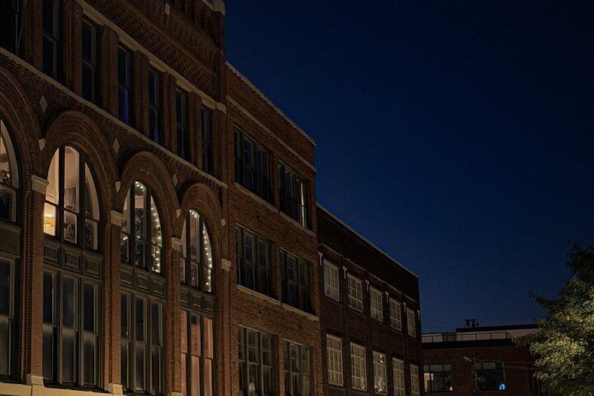 A brick building with arched windows and a dark sky. 1