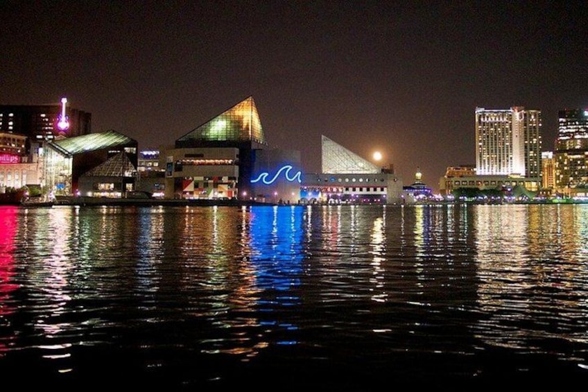 A nighttime cityscape with illuminated buildings reflecting on the water. 2