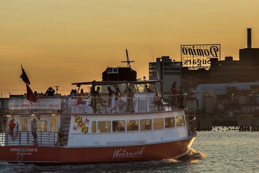 A sightseeing cruise boat named 'Annmarie II' with passengers, a city skyline in the background, and a sunset. 5