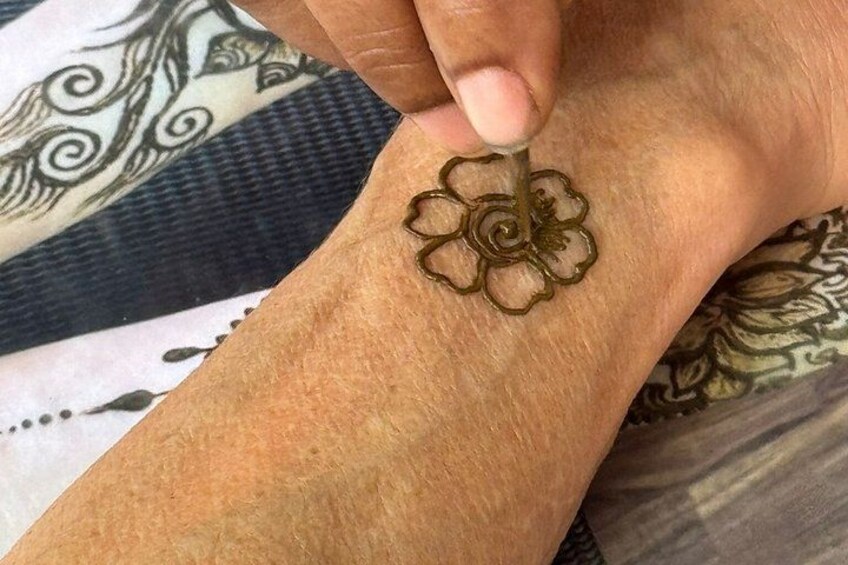 A hand with a henna design on the wrist. 4