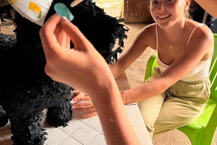 A person holding a black fluffy object, possibly a toy or pet, and sitting on a green chair. 3