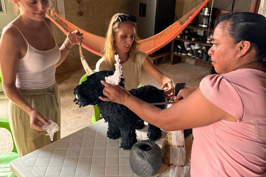 Three people interacting with a black dog on a table. 5