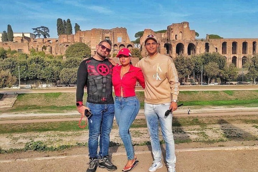 Tre persone in piedi di fronte a rovine antiche con archi e colonne. 5