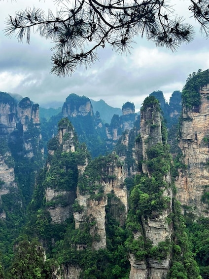A landscape of towering limestone cliffs with dense green vegetation. 2