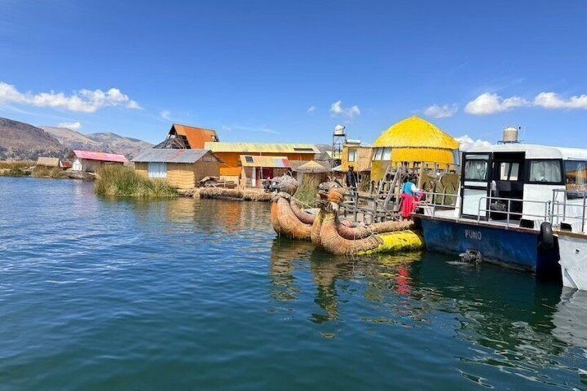 A boat named 'Fundo' docked near colorful buildings and a large yellow structure. 5