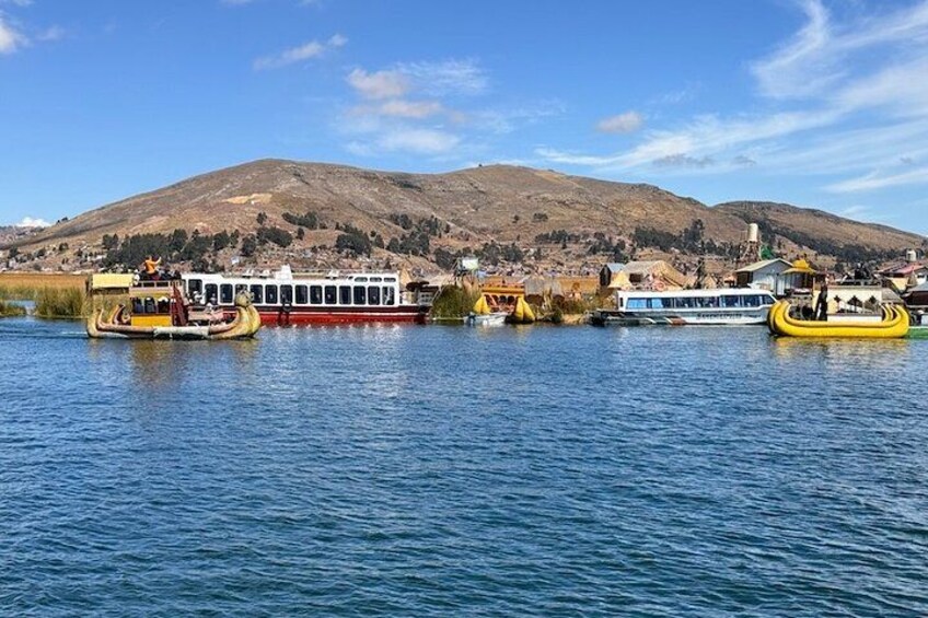 A river with boats, a hill in the background, and a town across the water. 3
