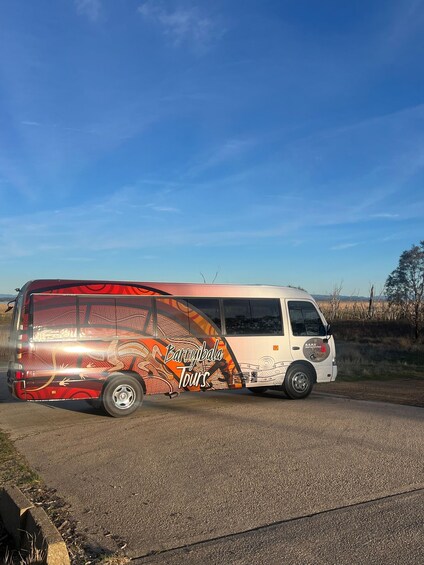 A tour bus parked on a road with a clear sky. 2