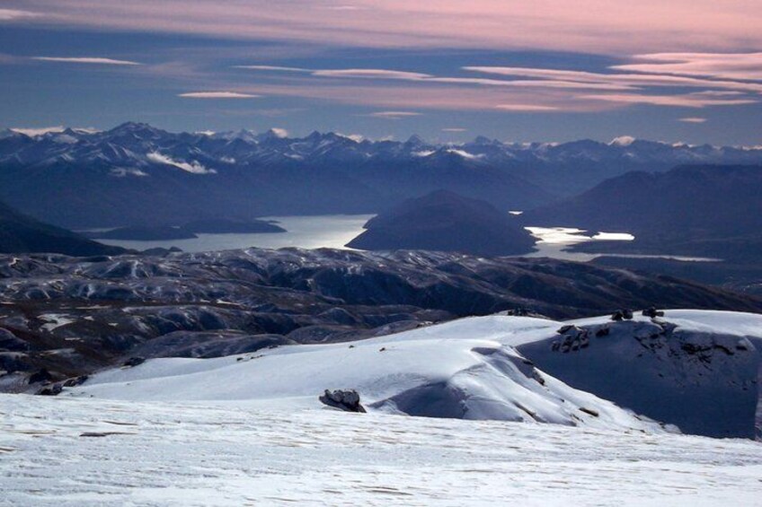A snow-covered mountain landscape with a lake and distant mountains. 2