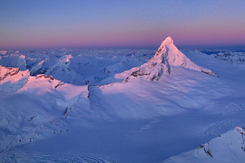 A snow-covered mountain peak at sunset. 5