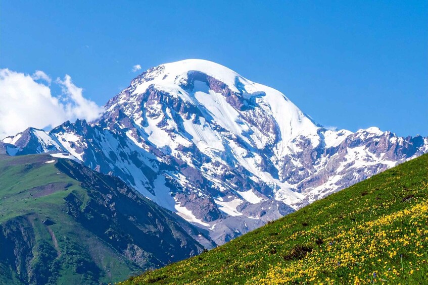 A snow-capped mountain with a clear blue sky. 1