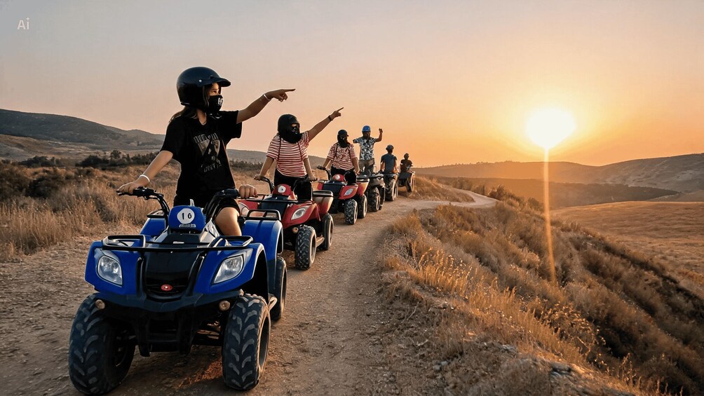 A group of people riding ATVs on a dirt path during sunset. 2