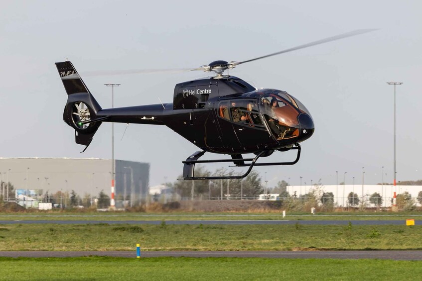 A helicopter with the registration PH-HCH taking off from a runway. 2