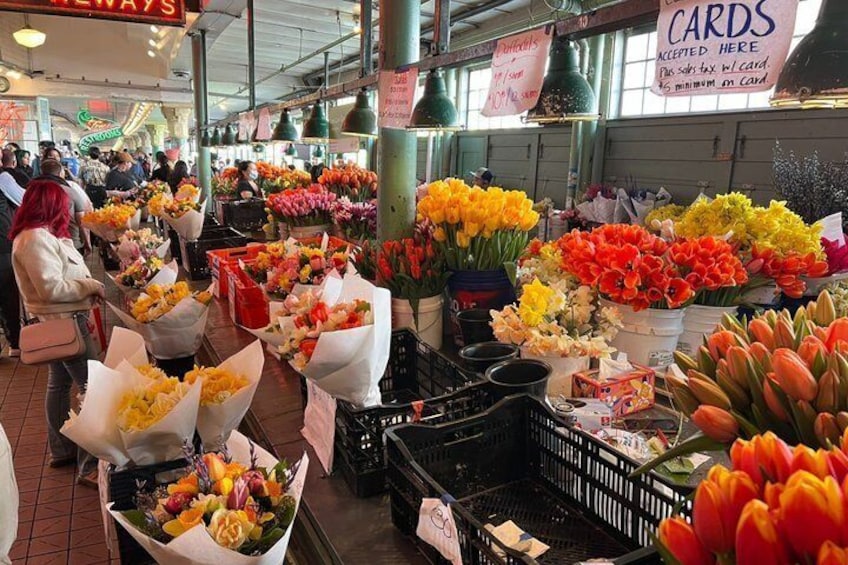 A flower market with various flowers in baskets and crates. 5