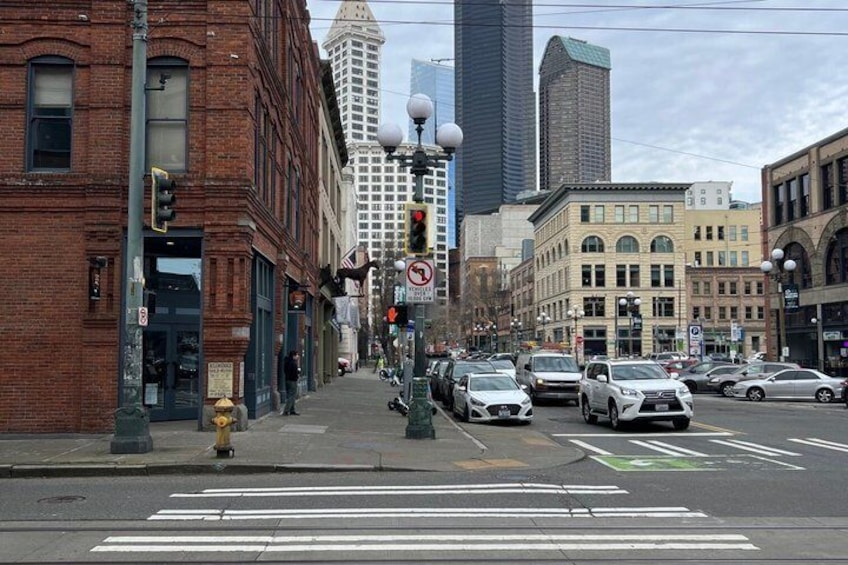 A city street with buildings, cars, and a traffic light. 2