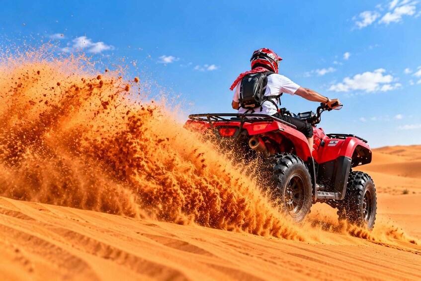 A person riding a red ATV through a sandy desert landscape. 2