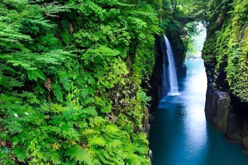 A waterfall in a lush green canyon. 4
