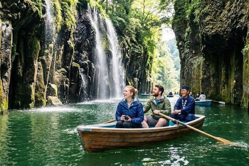 A narrow river with a waterfall, surrounded by rocky cliffs and dense greenery. 1