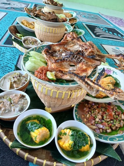 A variety of dishes including grilled meat, soups, and salads, arranged on a table with a patterned tablecloth. 2
