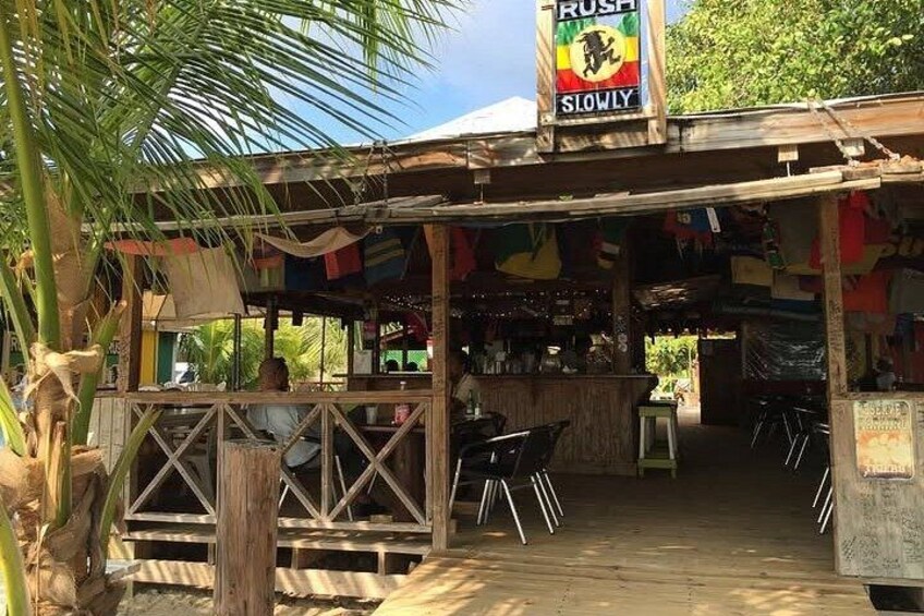 A wooden outdoor seating area with a sign that reads 'RUSH SLOWLY.' 3