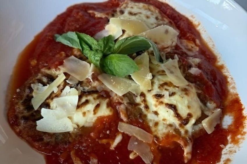 A plate of pasta with tomato sauce, cheese, and basil. 2