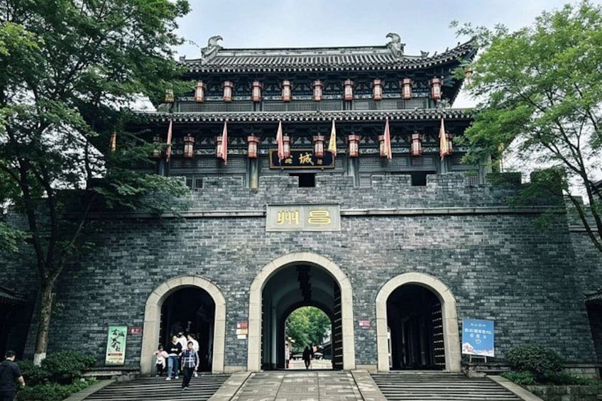 A traditional Chinese building with a tiled roof, arched entrance, and hanging lanterns. 1