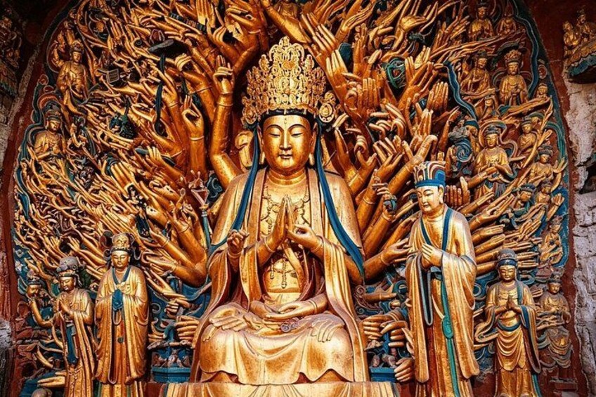 A large golden Buddha statue surrounded by smaller figures, set against a detailed mural. 2