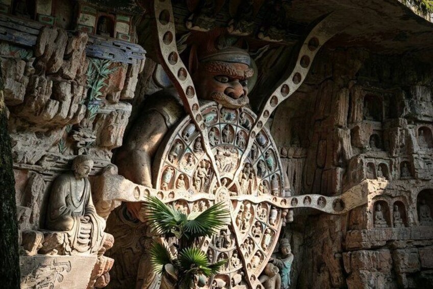 A large stone sculpture with intricate carvings, including a central figure with outstretched arms and surrounding smaller figures. 5