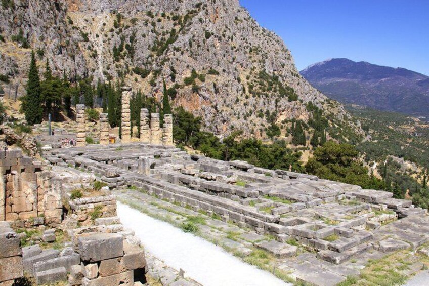 Ancient ruins with stone steps and columns, set against a mountainous backdrop. 2