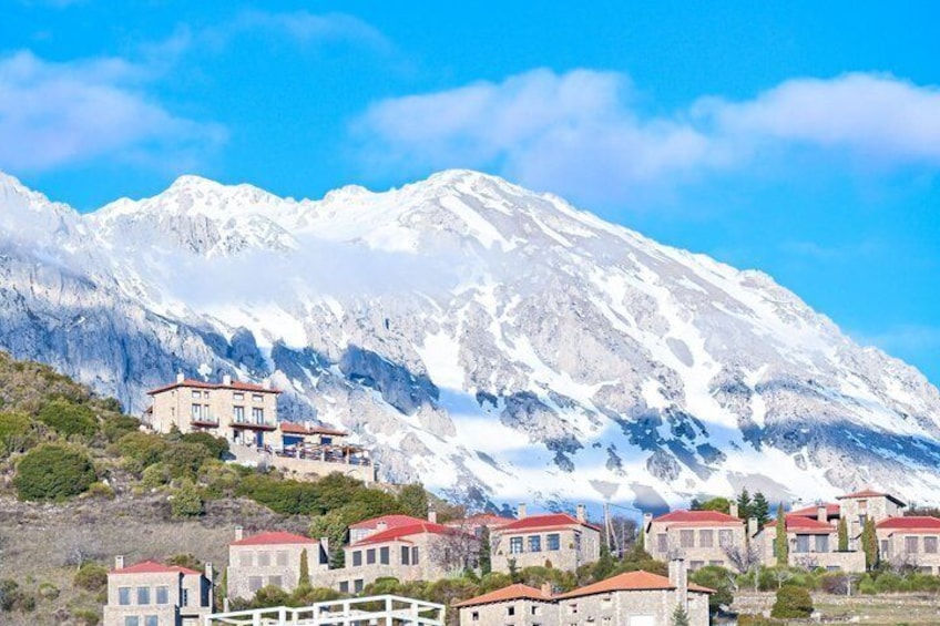 A snow-capped mountain, a red-roofed building, and a white fence. 5