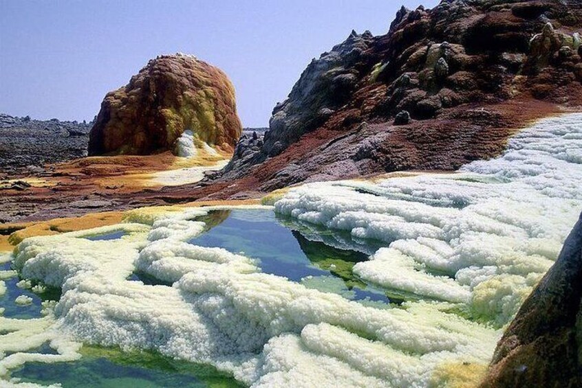 A geothermal area with mineral deposits and a large rock formation. 5