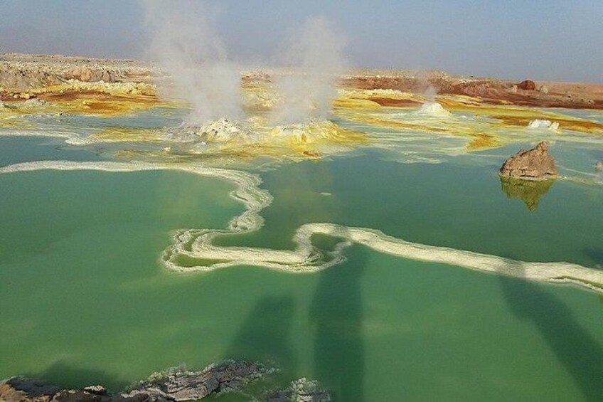 A geothermal area with mineral deposits and steam vents. 1