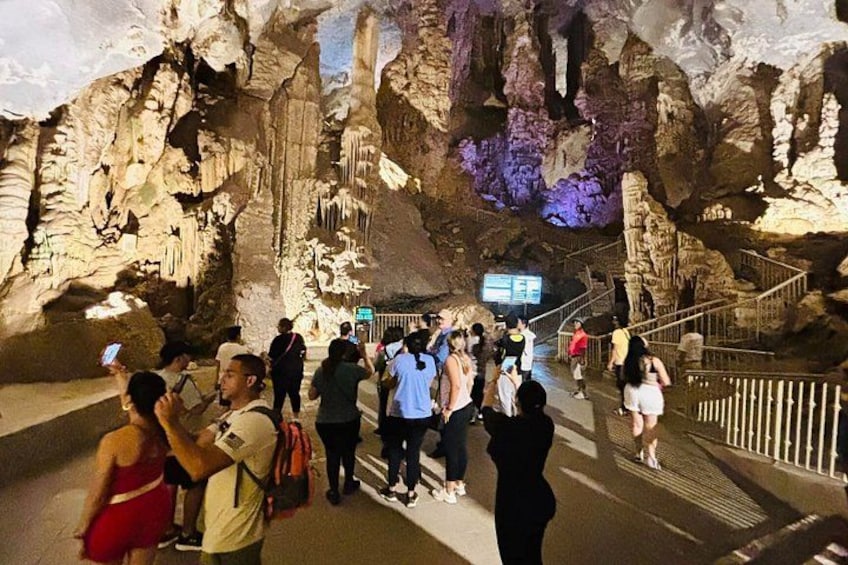 A cave with stalactites and a crowd of people. 2