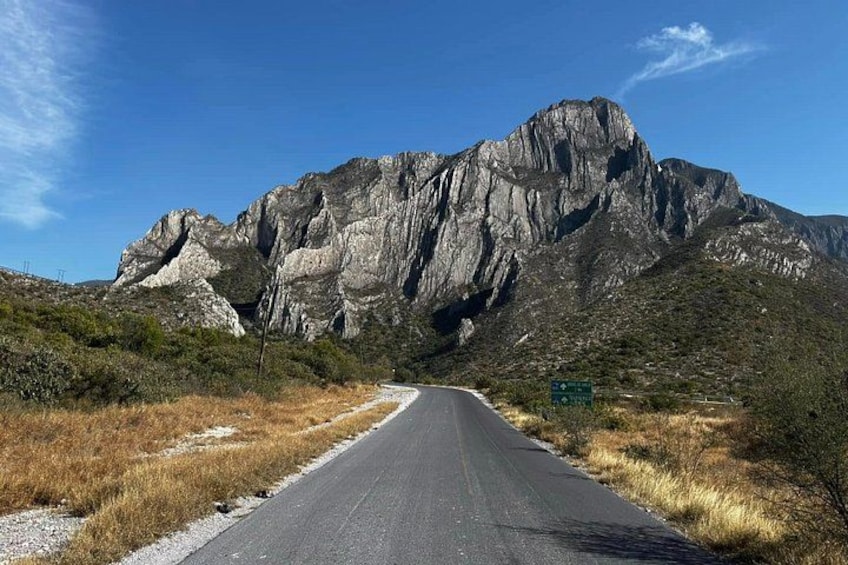 A road leading towards a rocky mountain. 4