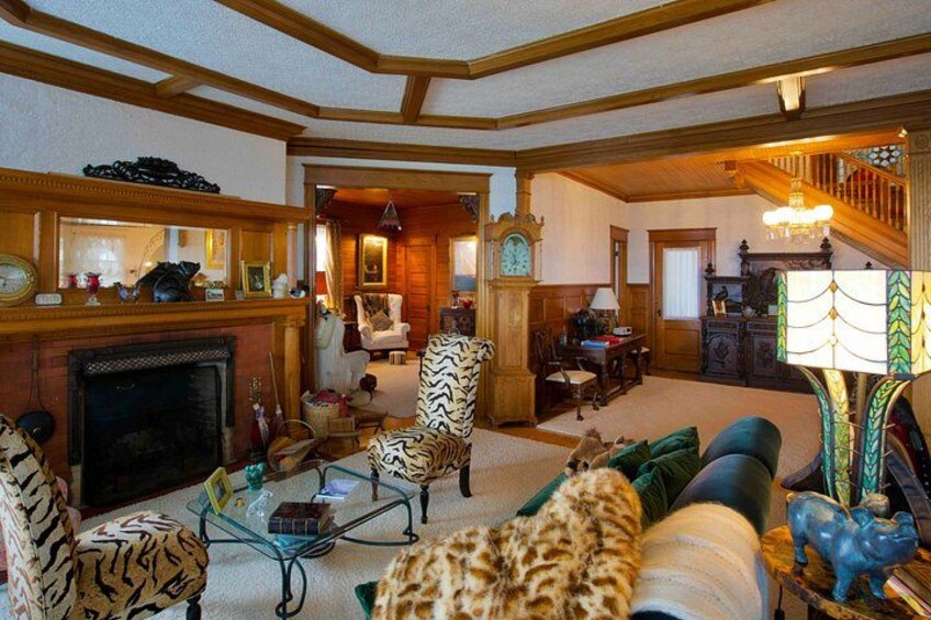 A cozy living room with a fireplace, leopard-print armchairs, and a staircase. 3