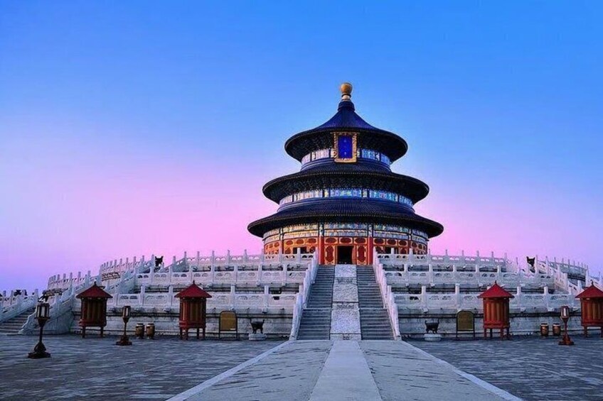 A traditional Chinese pagoda with a circular base and multiple tiers, surrounded by a white wall with red lanterns. 1