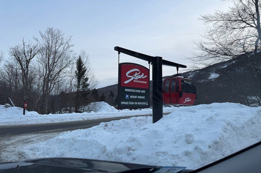 A snow-covered road with a ski lift and a sign for Stowe Mountain Resort. 5
