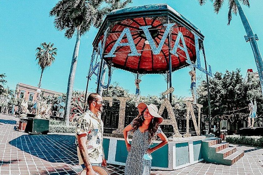 A man and a woman standing in front of a sign with the letters 'AVA' on it. 4