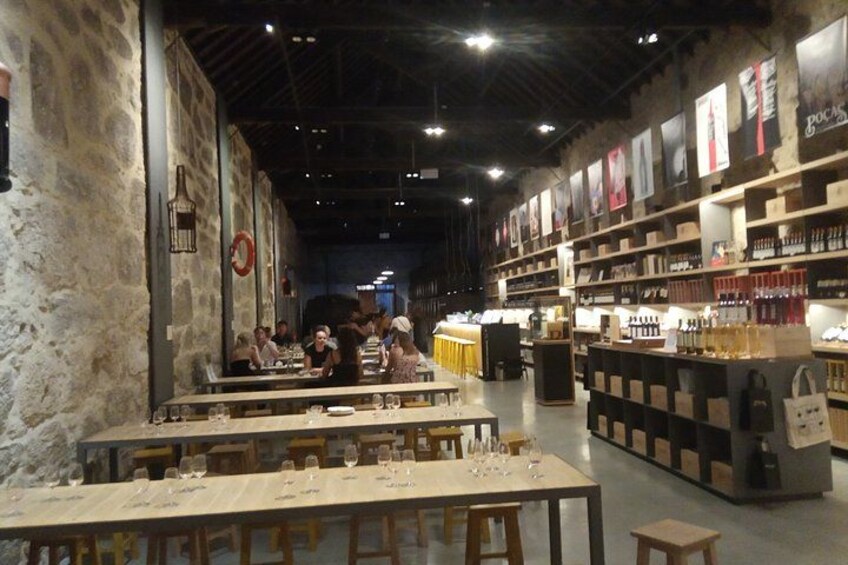 A restaurant with tables, chairs, and a wine display. 3